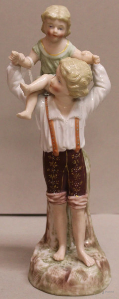 Bambini che giocano, scultura  in porcellana a decoro policromo, marcata, h.21 cm.