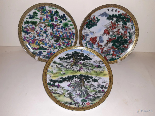 Lotto di tre piattini da muro in porcellana orientale a decori policromi, (difetti),diam. 20 cm.