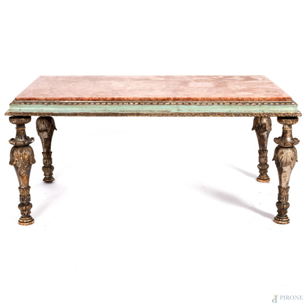 Tavolinetto basso con piano in marmo su struttura in legno intagliato e laccato, XX secolo, cm 44x101x61, (segni di usura, scalfiture, fessurazioni, rotture, fori di tarlo, difetti)