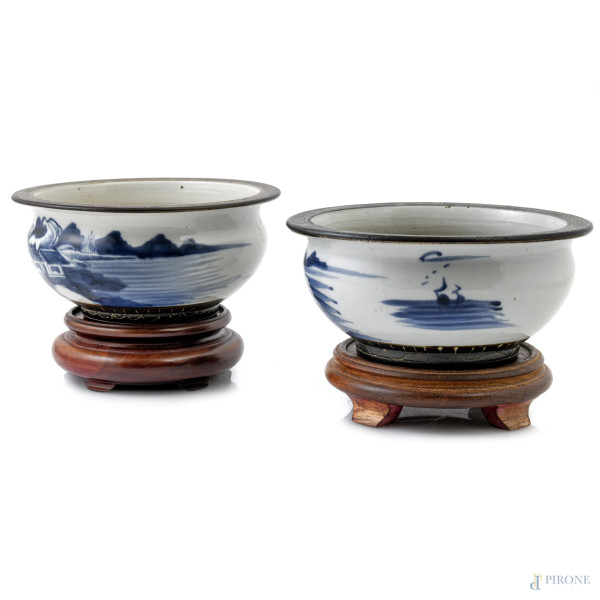 Coppia di portabonsai in ceramica dipinta nei toni del bianco e del blu con scene di paesaggio, su base in teak, XX secolo, cm 13,5x19,5, (segni di usura, difetti)