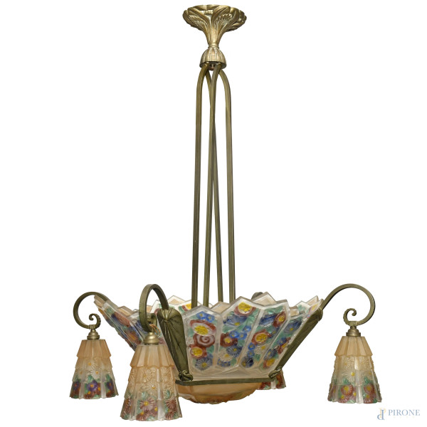 Lampadario con struttura in ferro battuto, composto da una coppa centrale e affiancata da quattro paralumi a campana. Gli elementi in vetro presentano decorazione ispirata a motivi floreali, XX secolo, cm 88x55x55 circa
