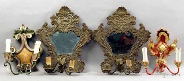 Lotto composto da due coppie di appliques a due luci in legno e metallo, h. massima 39 cm.