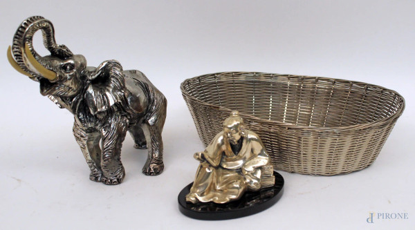 Lotto composto da un elefantino, un cestino e una figura orientale in metallo argentato, H massima 18 cm.