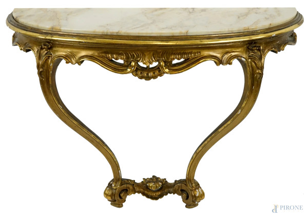 Consolle a mezzaluna in legno dorato ed intagliato, XX secolo, piano in marmo, due gambe mosse desinenti a ricciolo, cm h 64,5x87,5x31, (difetti).