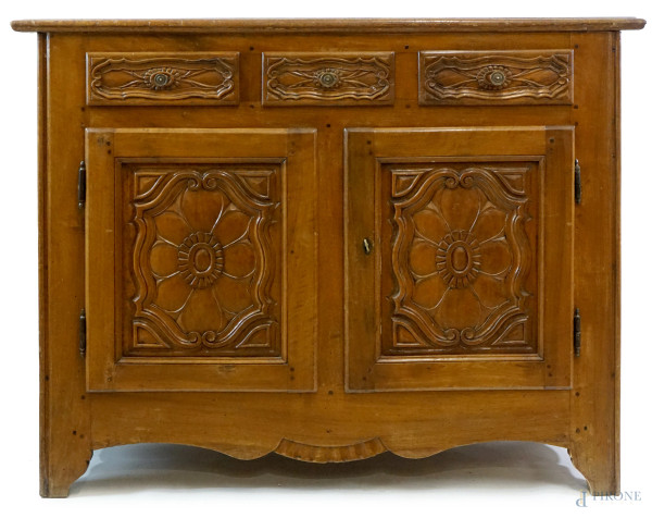 Credenza in noce, Piemonte, XVIII secolo, a tre cassetti pannellati e due sportelli con decori intagliati a motivi floreali, cm h 93x125x52, (difetti)