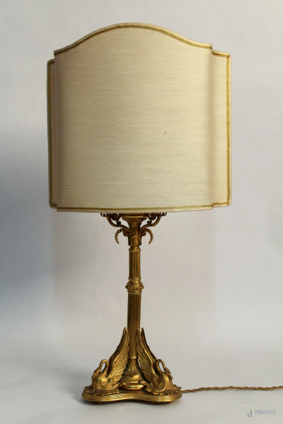 Lampada da tavolo in bronzo dorato sorretta da cigni, primi Novecento, H 60 cm.