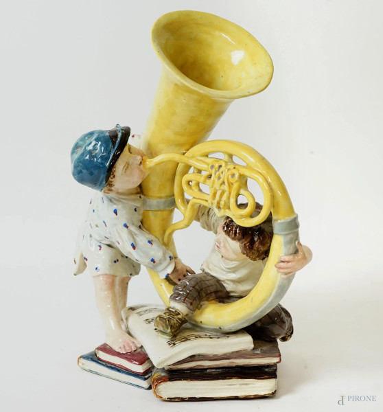 Fanciulli suonatori di tuba, gruppo in porcellana policroma, cm 28,5, inizi del XX secolo, (lievissimi difetti).