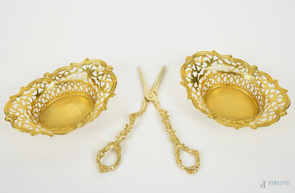 Lotto composto da una coppia di centrini traforati ed un paio di forbici da uva in metallo dorato, lunghezza max cm 18, XX secolo.