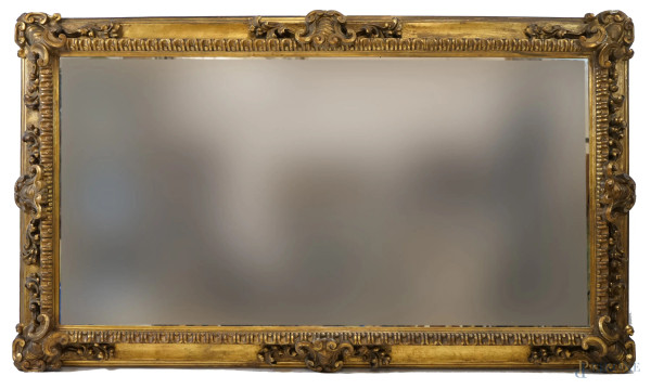 Specchiera di linea rettangolare in legno intagliato e dorato, inizi XX secolo, cm h 197x115, (difetti).