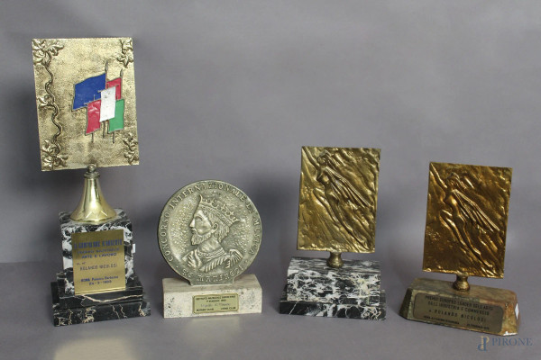 Lotto composto da quattro premi ricevuti dal Maestro Rolando Nicolisi a forme e materiali diversi, H massima 42 cm.