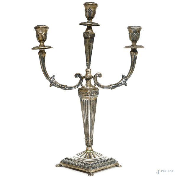 Candelabro in argento cesellato a tre fiamme, busto a obelisco rovesciato e scanalato, Vercelli, anni 60, altezza cm 38,5, peso gr. 350, (difetti)