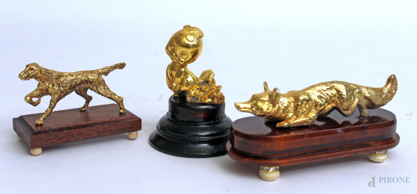 Lotto composto da tre sculture a soggetti diversi in bronzo dorato su basi in teak, h. massima 8 cm.