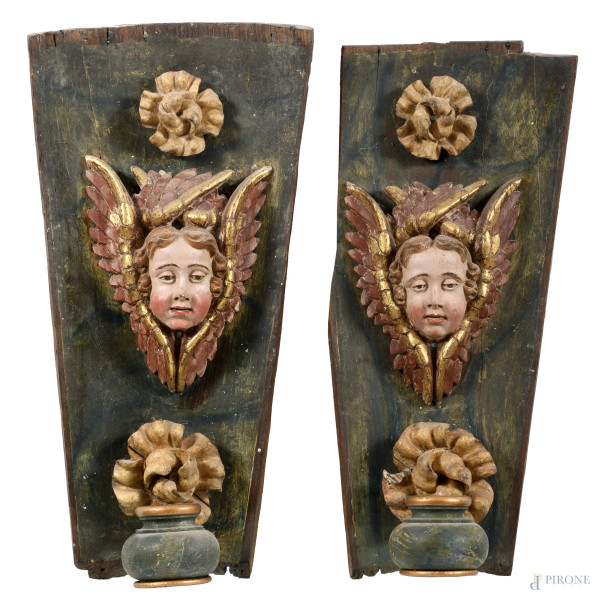 Coppia di appliques in legno dipinto e dorato con teste di cherubini e fiori a rilievo, XIX-XX secolo, cm 61x31x19, (segni di usura, fessurazioni, cadute di colore e doratura, difetti)