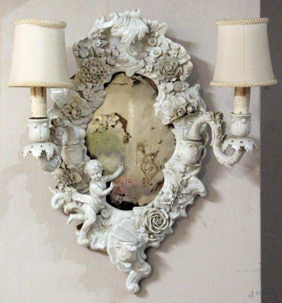 Specchiera applique a due luci in porcellana bianca con putto e fiori a rilievo, altezza 47 cm, (difetti).