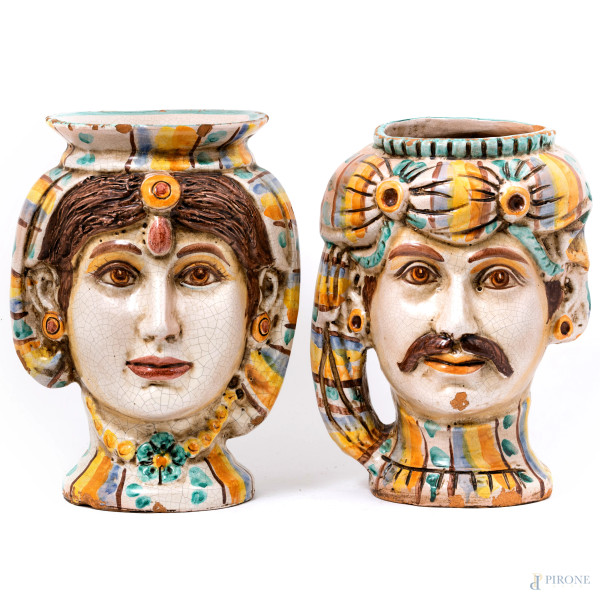 Coppia di vasi in ceramica di Caltagirone raffiguranti teste di mori, XX secolo, altezza cm 34, (sbeccature, cadute di smalto stannifero, felature, difetti)