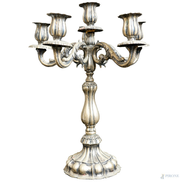 Candelabro a sei fiamme in argento sbalzato e cesellato, caratterizzato da cinque braccia a volute e  fusto a balaustro poggiante su base baccellato, titolo dell'argento 800 , inizi XX secolo, cm h 37, peso gr. 1280 circa