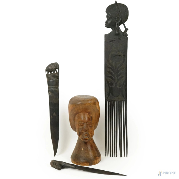 Lotto di quattro oggetti di artigianato africano in legno, misure max cm 51x7,5, XX secolo.