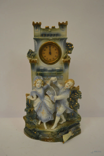 Orologio a torre con scena romantica a rilievo in porcellana policroma, primi 900, h. 33 cm.