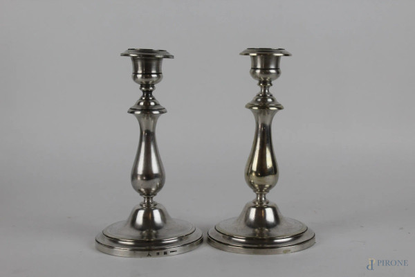 Coppia di candelieri in metallo argentato, fusto tornito su base circolare, altezza cm. 18, XX secolo.
