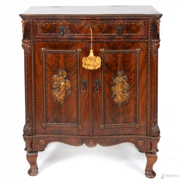 Mobiletto impiallacciato in piuma di mogano a due sportelli e un cassetto al fronte, con intagli a rilievo di allegorie delle quattro stagioni, XX secolo, cm 100x85x46, (segni di usura, graffi, scalfiture, rotture, fori di tarlo)