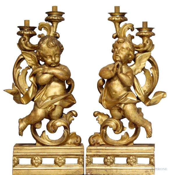 Importante coppia di portaceri sorretti da putti alati in legno dorato, poggianti su basi, periodo XVIII sec, altezza cm. 86.