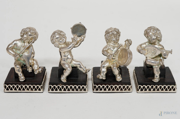Quattro puttini musicanti in argento, XX secolo, basi in legno, cm h 9x5x5, peso lordo gr.860, (lievi difetti ed un restauro)
