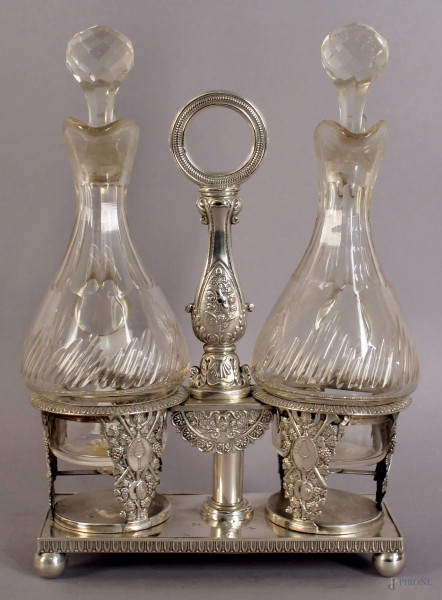 Oliera in metallo sbalzato,cesellato e argentato completo di due flaconi in cristallo, H.25 cm, XIX sec.
