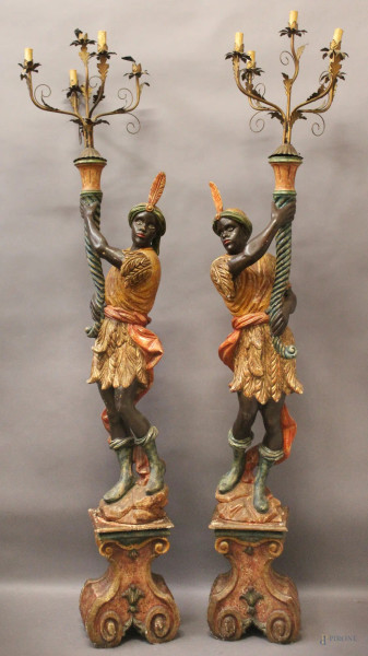 Coppia di mori in legno policromo reggenti candelieri in ferro battuto a cinque luci, H massima 205 cm.