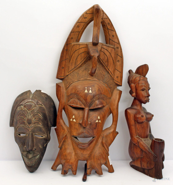 Lotto di due maschere ed una statua a soggetto femminile in legno intagliato, arte africana primi 900.