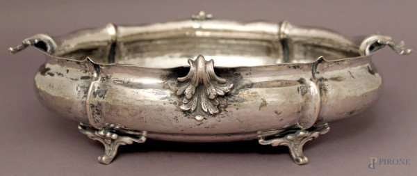 Centrotavola di linea centinata in argento cesellato poggiante su quattro piedini, cm 8x32x21, gr. 720.