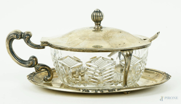 Formaggiera in argento con sottopiatto ovale e presa a voluta, vaschetta in cristallo controtagliato e cucchiaino d'accompagno (non pertinente), cm h 8x16,5x10,5, peso gr. 168