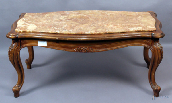 Basso tavolo da salotto in noce di linea rettangolare centinata, particolari intagliati, piano in marmo, altezza 45x101x56 cm.