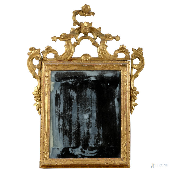 Specchiera in legno intagliato e dorato con elemento apicale a volute, XIX secolo, cm 94x67, (segni di usura, perdite di doratura, scalfiture, rotture, mancanze, difetti)