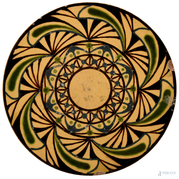 Piatto in maiolica smaltata con decoro policromo astratto,  diametro cm 30, XX secolo, firmato al retro a graffio "E. Bechard", (difetti)