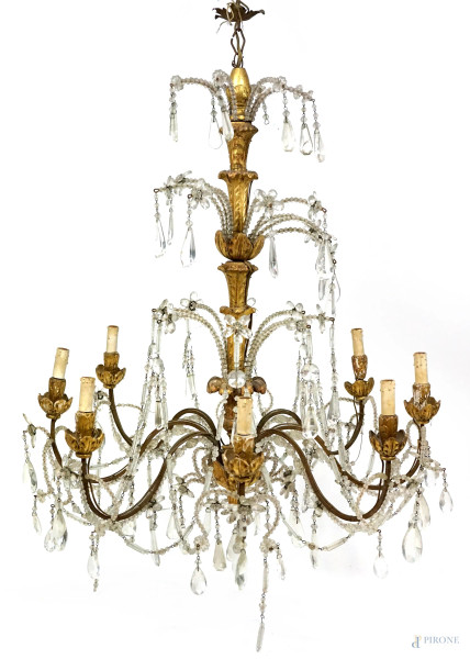 Lampadario in legno dorato ad otto luci, XVIII secolo, fusto e bracci intagliati a motivi floreali con pendenti in cristallo, cm h 114x82, (difetti).