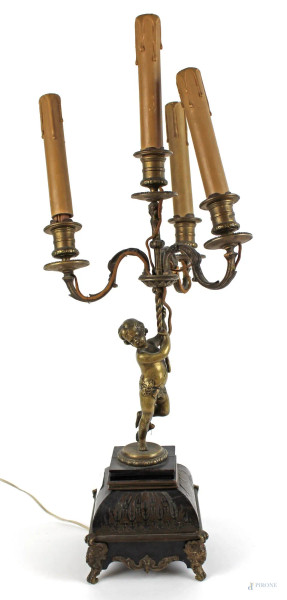 Candelabro in bronzo a quattro fiamme, fusto a foggia di putto, base in legno con particolari intarsiati, altezza cm. 65, XIX secolo, (difetti).