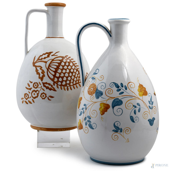 Coppia di versatoi in ceramica di Faenza decorati a motivi floreali nei toni del bianco, arancione e blu, XX secolo, altezza massima cm 31