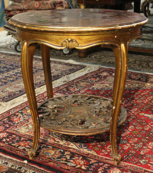 Tavolino da salotto di linea tonda in noce e radica con particolari intagliati e dorati, H 60 cm, diam. 60 cm.