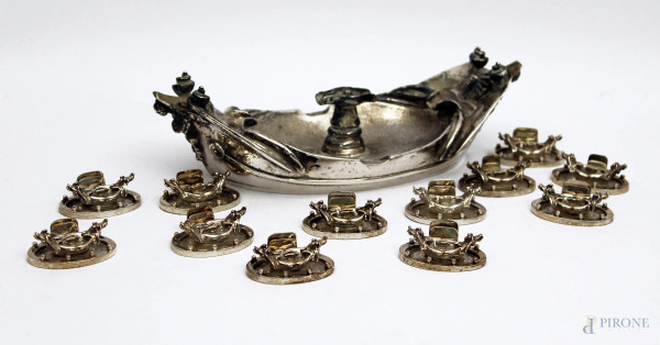 Lotto composto da un centrotavola in argento barcaccia romana, h. cm 6,5x24 e dodici segnaposti della stessa forma.
