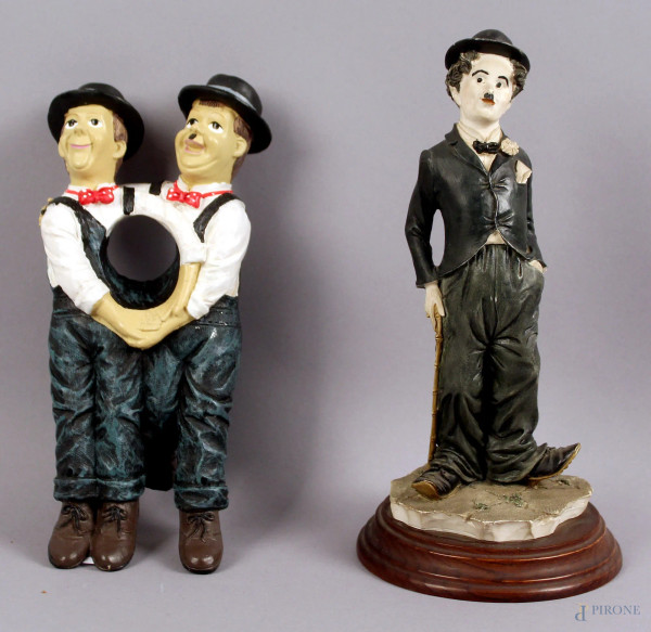 Lotto composto da una scultura raffigurante Chaplin ed un porta bottiglie in resina, altezza max. 24 cm.
