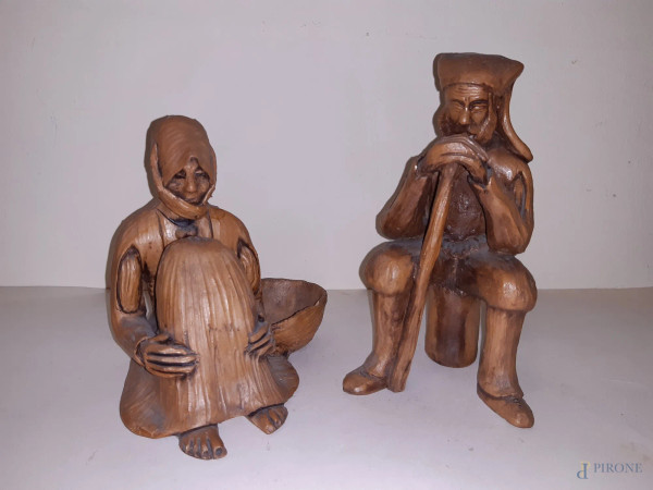 Lotto di due sculture in terracotta raffiguranti uomo seduto con Bastone e donna seduta con cesta, marcate, h 20 cm.