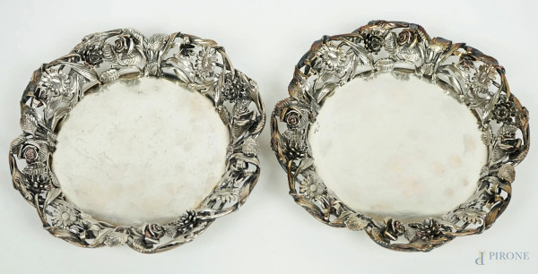 Due piattini in argento, Argentiere Enrico Goretta, XX secolo, cavetto liscio, tesa traforata e cesellata a motivi floreali, cm 2,5x16,2, peso gr. 590