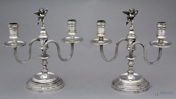 Coppia candelieri in argento a due fiamme, sormontate da putti, altezza cm. 20,5, gr. 994.