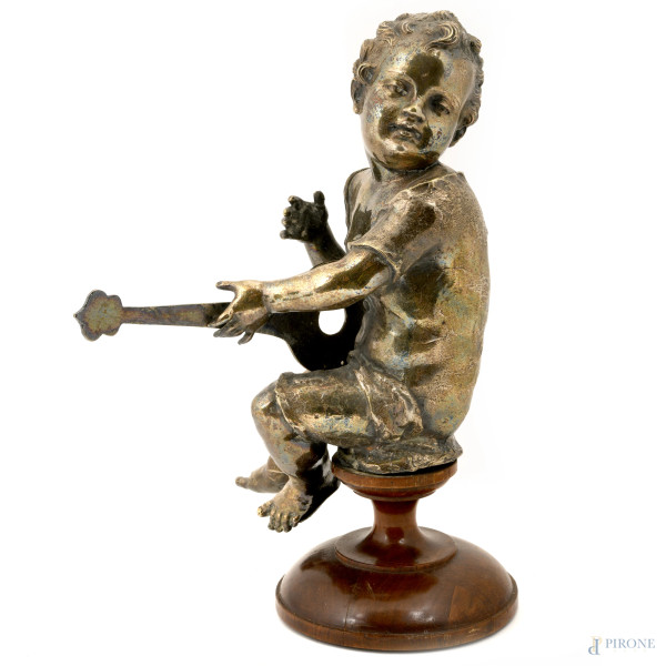 Scultura in metallo argentato raffigurante bambino a guisa di putto che suona uno strumento a cor...
