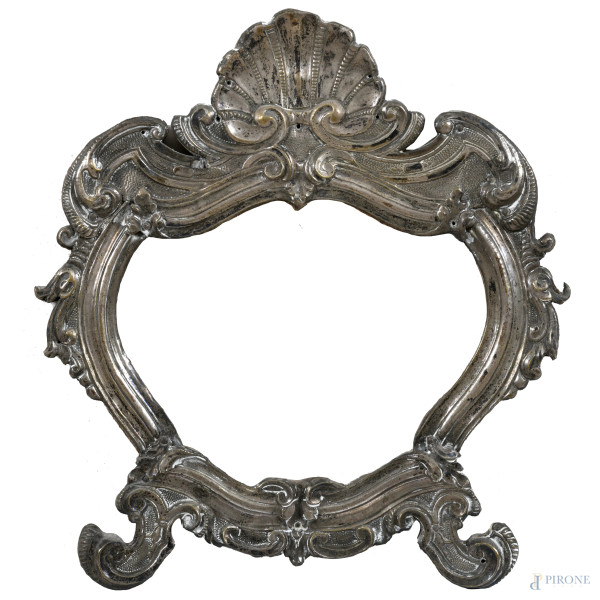 Cornice a guisa di cartagloria rivestita in metallo argentato cesellato e sbalzato, XX secolo, cm 30x26; luce cm 13,5x17,5, (segni di usura)