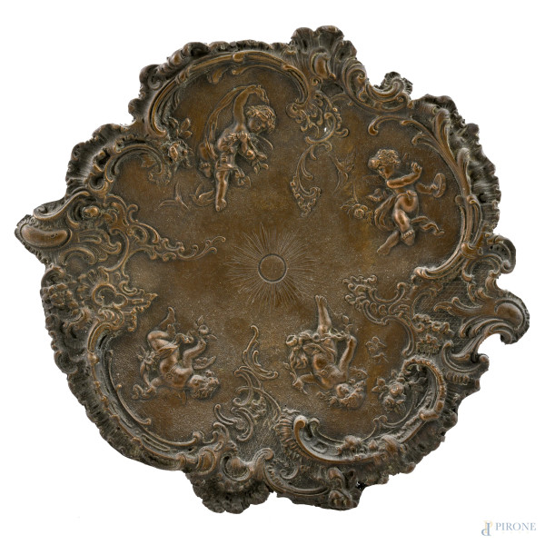 Piatto in bronzo cesellato a volute vegetali e putti, XX secolo, diametro cm 29,5, (segni di usura)