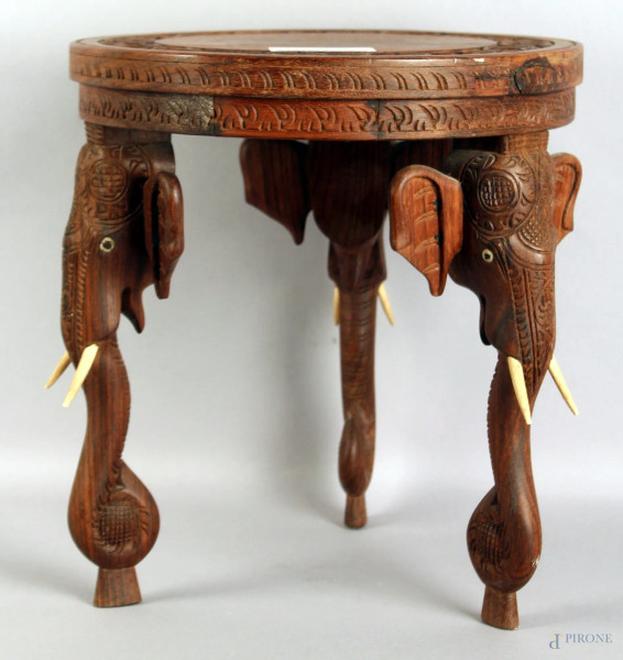 Basso tavolino in Teak di linea tonda, poggiante su tre gambe intagliate a forma di teste d&#39;elefante, altezza cm 33, arte coloniale primi &#39;900.