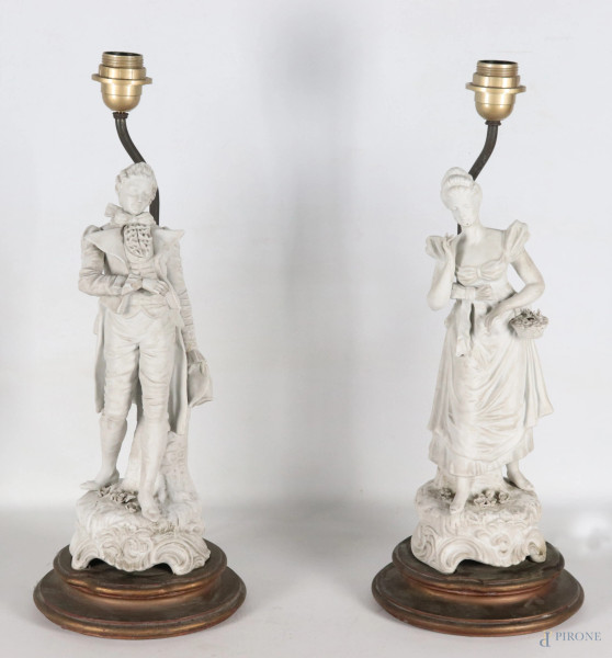 Lotto di due lampade da tavolo con sculture in bisquit raffiguranti dama e cavaliere su base in legno, XX secolo, altezza massima cm 54, (segni di usura, scalfiture, rotture, restauri, da revisionare)