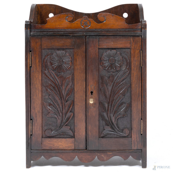 Pensile in legno intagliato a doppia anta con interno a vani e cassetti, XX secolo, cm 44,5x32x17,5, (segni di usura, scalfiture, difetti)