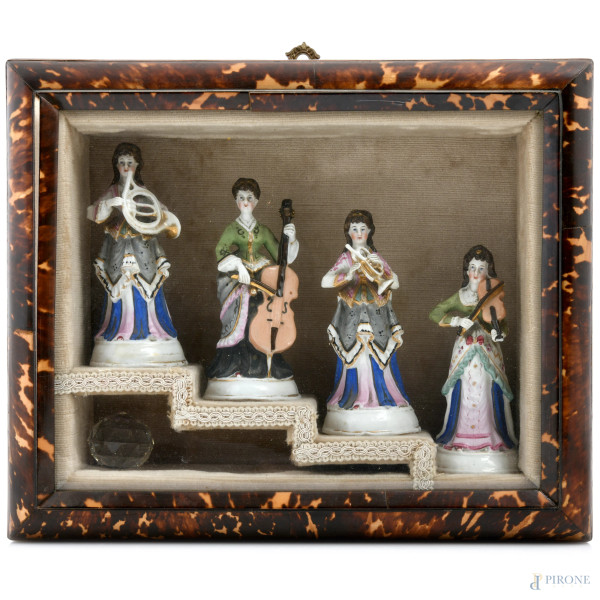 Composizione di quattro sculture in porcellana raffiguranti fanciulle musicanti entro cornice a bacheca, XX secolo, misure complessive cm 28,5x34, (segni di usura, difetti)